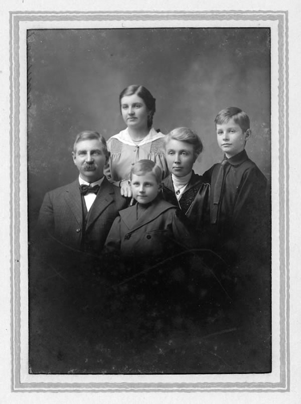 [ Norman (front) as a boy, with family ]