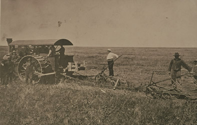 [ The first steam tractor owned by the Doukhobor commune, with Peter Verigin behind it, 1905, Unknown, UBC Special Collections 27-18 ]