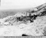 Miners working, eating within view of cabins and flumes, Hunker Creek