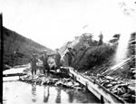 Four miners engaged in sluicing operation