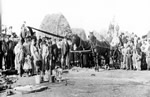 Verigin and Holobova, in buggy, inspect steam threshing machine, Blaine Lake, Saskatchewan