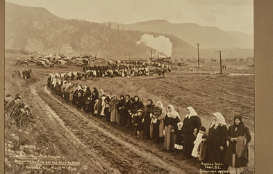 [ La rue de la maison de Verigin borde par la foule qui attend le cercueil , Hughes Bros, Doukhobor Discovery Centre, Castlegar, BC  ]